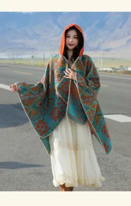 Model wearing a vintage ethnic hooded poncho with geometric patterns on a mountain road