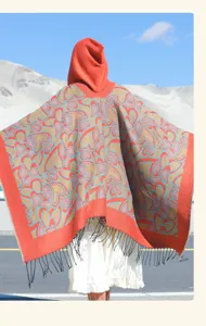 Détail de dos d'un poncho à capuche à motif cœurs avec franges dans un paysage désertique