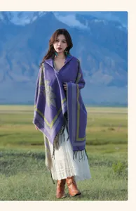 Asiatisches Model in lila Ethno-Schal mit Kapuze vor einer weiten Berglandschaft