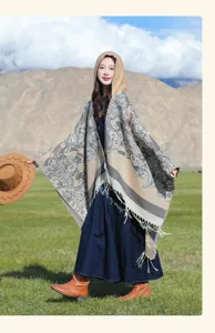 Vue détaillée du poncho en maille à fleurs et capuche dans un décor extérieur pittoresque.