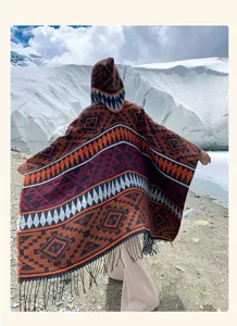 Rückansicht eines Bohème-Strickponchos mit Kapuze und Ethno-Mustern im Schnee