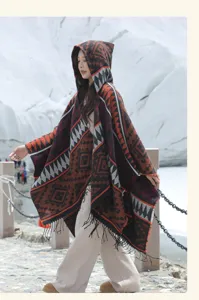 Boho Strickponcho mit Kapuze, geometrischem Muster und Fransen, im Freien von Model getragen