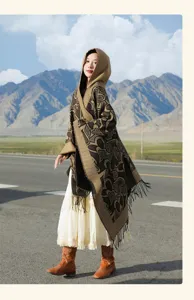 Photo de mode d'une femme portant un poncho marron à capuche avec des franges et des cœurs