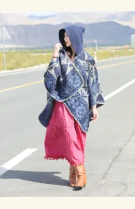 A full-length view of a hooded ethnic patterned winter poncho shawl on a scenic desert road