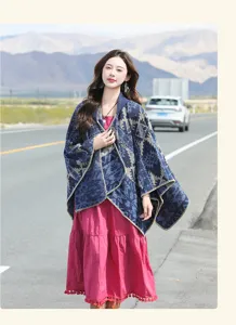 Detailed macro view of bohemian style blue hooded poncho shawl on a model in travel scene