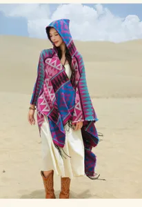 Frau im böhmischen Strickponcho mit Kapuze und geometrischen Mustern in der Wüste