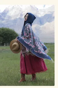 Portrait extérieur d'un modèle portant un poncho à capuche à glands et motifs de cœur