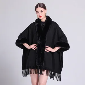 Detail eines schwarzen warmen Ponchos mit Webpelzkragen und elegantem Fransenbesatz