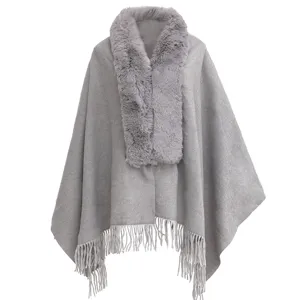 Vue détaillée du châle poncho gris avec col en fausse fourrure et franges.