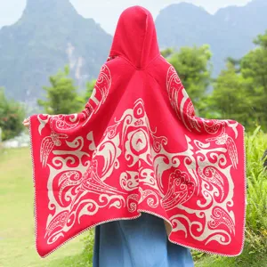 Detaillierte Rückansicht eines roten Strick-Ponchos mit Kapuze und cremefarbenem Muster