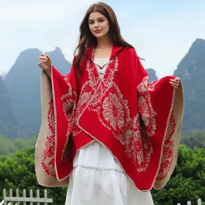 Frau trägt einen roten Strickponcho mit Kapuze und beige Blumenmustern im Freien