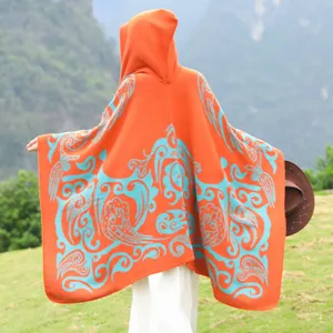 Rückansicht eines orangefarbenen Strickponchos mit Kapuze und blauem Muster