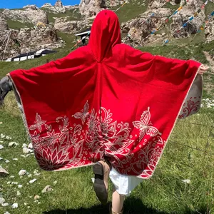 Vibrant red hooded faux cashmere knitted poncho with intricate white butterfly floral patterns