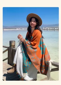 Ethno-Jacquard-Schal mit Quasten, getragen von einem Modell in malerischer Seenlandschaft