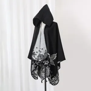 Detailed full view of black hooded knit poncho shawl with butterfly floral patterns
