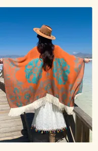 Rückansicht eines orangefarbenen Ponchos mit Quasten in einer malerischen Umgebung