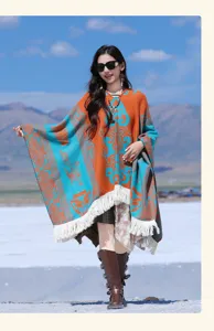 Outdoor-Lifestyle-Aufnahme eines bunten ethnischen Jacquard-Ponchos mit Fransen.