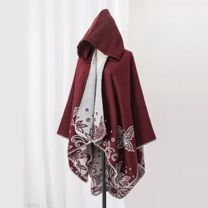 Elegant wine red hooded knitted poncho with butterfly floral pattern on mannequin