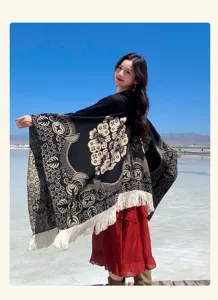 Detailansicht eines ethnischen Jacquard-Ponchos mit weißen Fransen bei einer Reisenden.