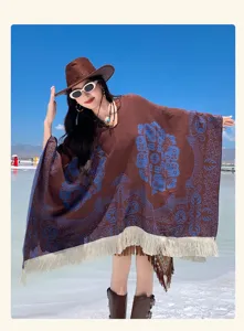 Detailansicht eines ethnischen Pullover-Ponchos mit blauem Blumenguard und weißen Fransen