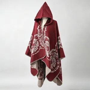 Detailansicht eines warmen dunkelroten Strickponchos mit Kapuze und Blumenmuster