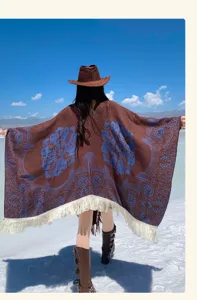 Detaillierte Rückansicht eines ethnischen braunen Jacquard-Ponchos mit eleganten weißen Fransen.