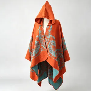 Detailansicht eines böhmischen Strickponchos mit Kapuze und orange-blauem Blumenmuster