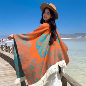 Ethnischer orangefarbener Quasten-Poncho mit türkisfarbenem Jacquard für Damenreisen.