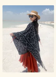 Fashionable leopard print knitted shawl with fringe detail on model in sunny beach