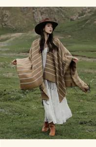 Detailed view of an ethnic striped knitted shawl with tassels in an outdoor mountain setting