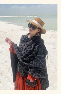 Model wearing a stylish leopard print knitted shawl with fringe for travel