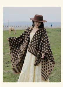 Full view of ethnic vintage knit poncho shawl worn by a model in a grassy landscape