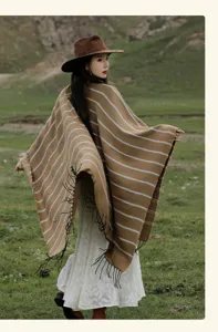 Detailed back view of a brown ethnic knit poncho featuring white stripes and black tassels.