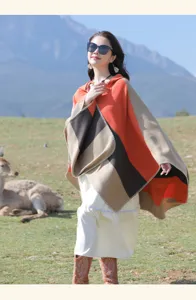 Detail view of an ethnic striped shawl poncho worn in an outdoor scenic mountain setting.