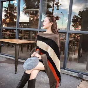 Detailed view of a stylish striped asymmetrical knit poncho shawl with fringe accents
