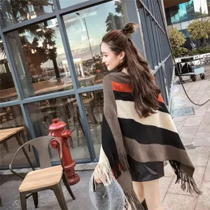 Stylish striped knit poncho with fringe details worn by an Asian model outdoors now
