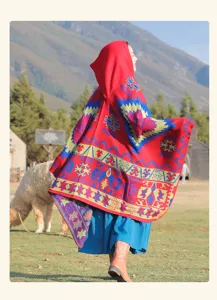 Détail d'une cape rouge à capuche ethnique à motifs dans un paysage montagneux