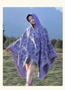 Frau trägt einen lila böhmischen Kapuzen-Strickponcho mit Herzmuster auf einer Wiese