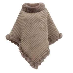Stylish oversized brown knitted poncho featuring a faux rabbit fur collar and asymmetrical hem