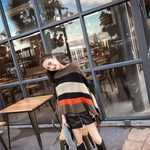 Fashionable striped knit poncho shawl with irregular fringe and tassel hem shown on model