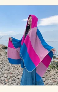 Detailed view of an ethnic striped hooded shawl for women in a scenic travel setting
