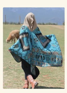 Vue arrière d'un poncho ethnique à capuche bleu sarcelle avec des motifs géométriques dehors