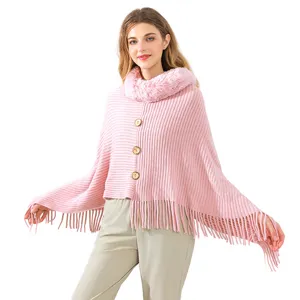 Women's pink knitted poncho sweater with faux fur collar and fringe tassels