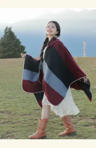 Stylish ethnic striped poncho shawl displayed in a scenic mountain landscape view