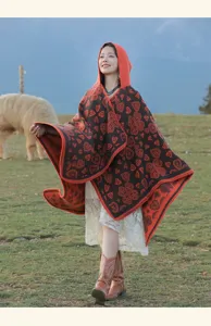 Eleganter Damen Strickponcho mit Kapuze im Ethno-Stil in malerischer Außenkulisse