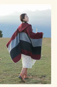 Elegant ethnic striped hooded cloak shawl for women against a mountain backdrop
