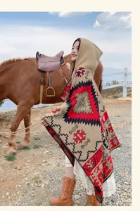 Modèle portant un châle poncho à capuche bohème ethnique près d'un cheval en plein air