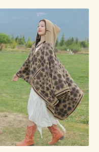 Ethno-Kapuzen-Strickponcho mit Herzmuster in einer natürlichen Außenumgebung.