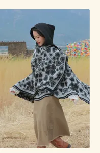 Modischer Strick-Poncho mit Kapuze und Herzmuster, getragen von einer Frau im Freien.