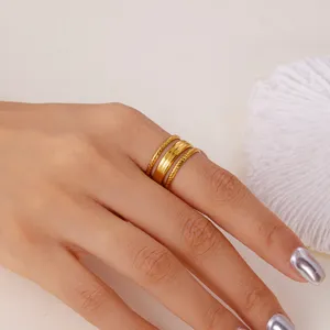 Detailaufnahme von drei vergoldeten Edelstahlringen, die an einem Finger getragen werden